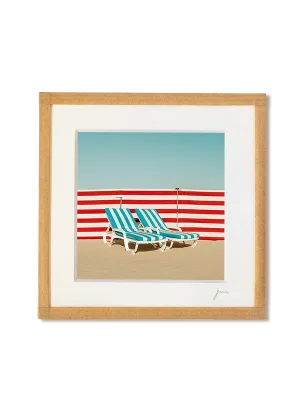 tirage photo petit format encadré à la main représentant deux transats de plage rayé bleus devant un paravent rayé rouge