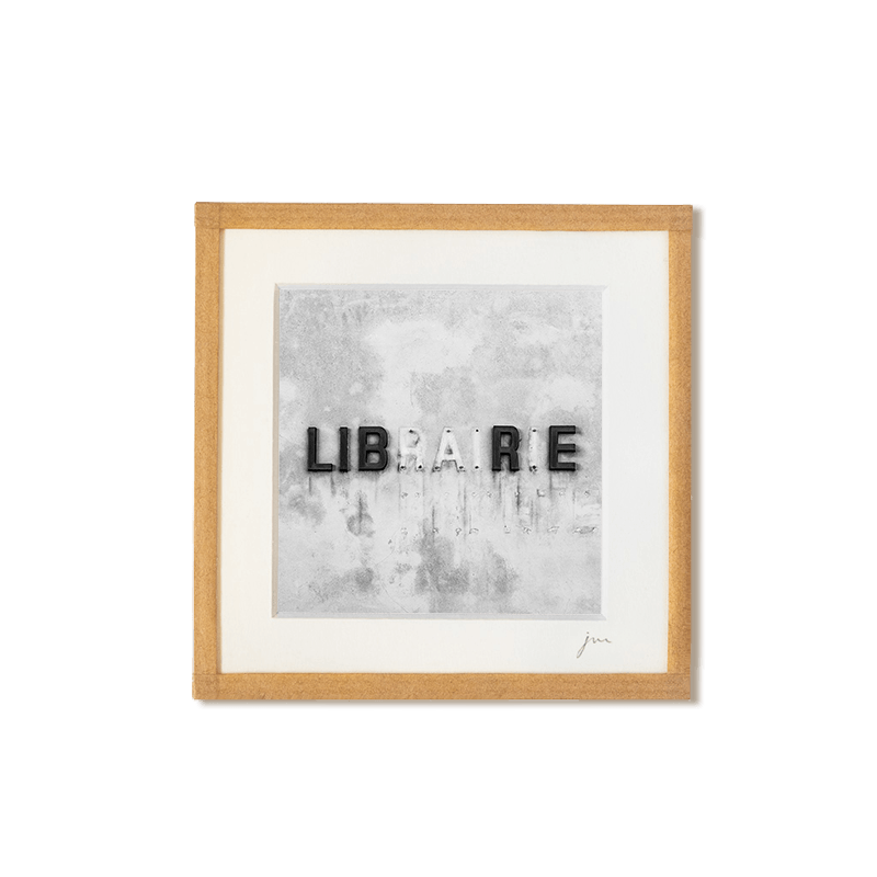 tirage photo petit format encadré à la main représentant le mot librairie écrit sur un mur avec lettres manquantes formant le mot libre