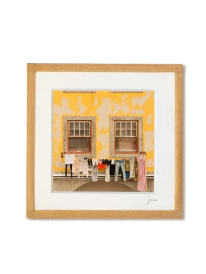 tirage photo petit format encadré à la main représentant du linge séchant devant une façade jaune à Porto