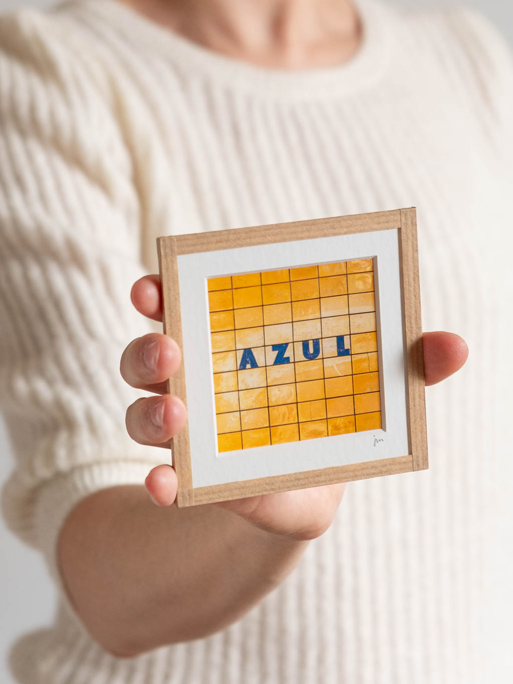 tirage photo petit format encadré à la main représentant un mur d'azulejos jaunes de Porto avec le mot Azul