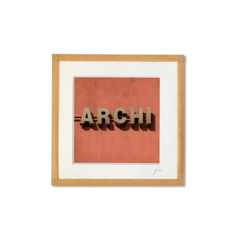 tirage photo petit format encadré à la main représentant le mot ARCHI sur mur orange