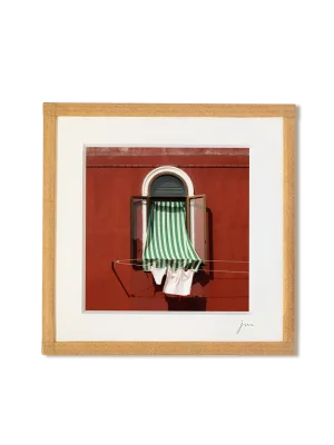 tirage photo petit format encadré à la main représentant une fenêtre avec un store rayé vert et linge qui sèche