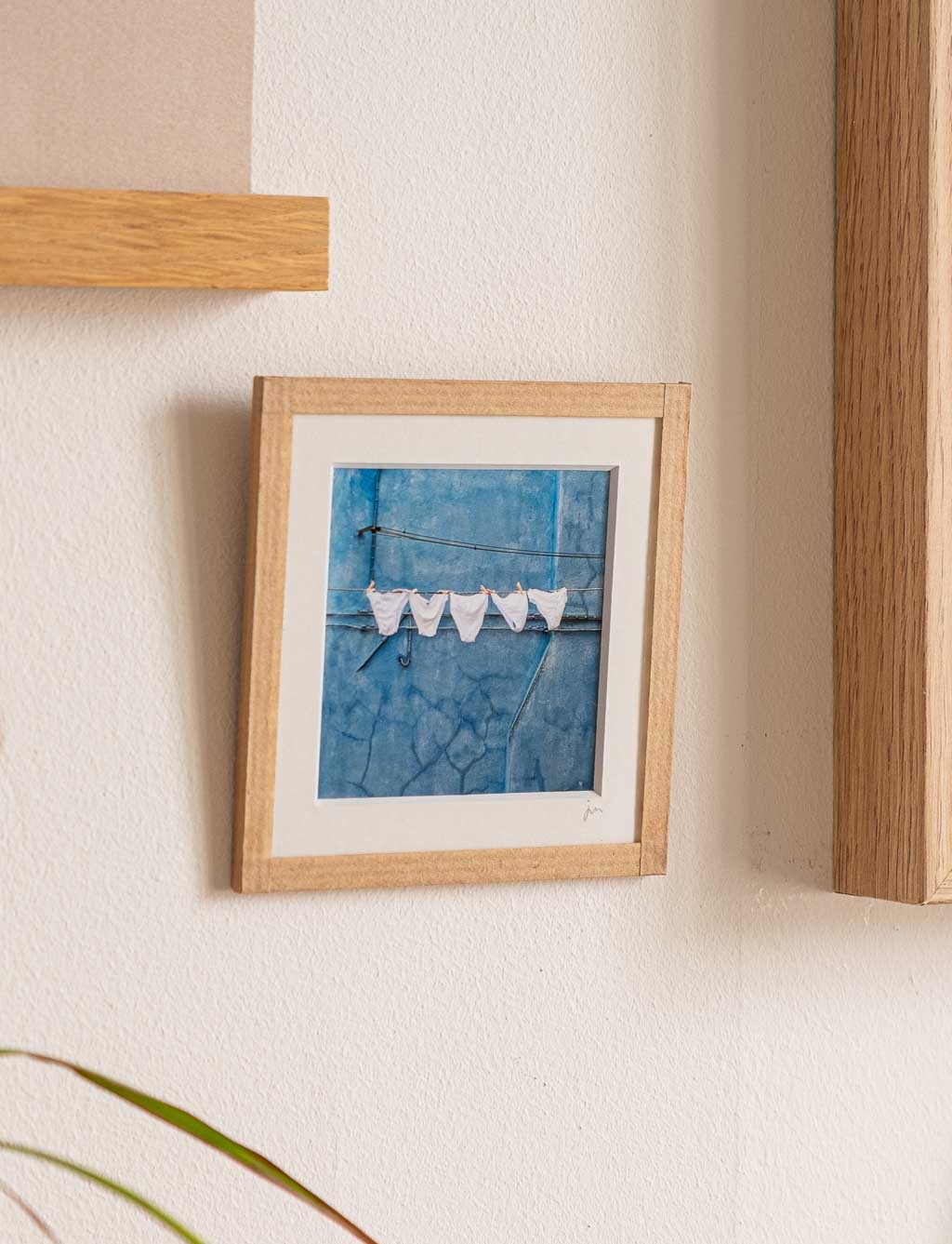 tirage photo petit format encadré à la main représentant des culottes blanches qui sèchent devant un mur bleu