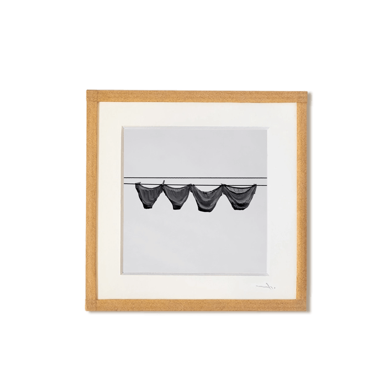 tirage photo petit format encadré à la main représentant des culottes qui sèchent sur un fil devant un mur blanc