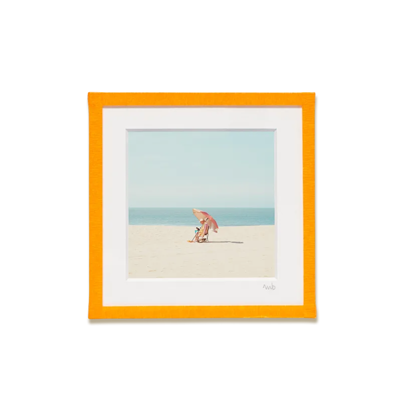 tirage photo petit format encadré à la main représentant un homme assis sous un parasol orange sur la plage d'Ostende