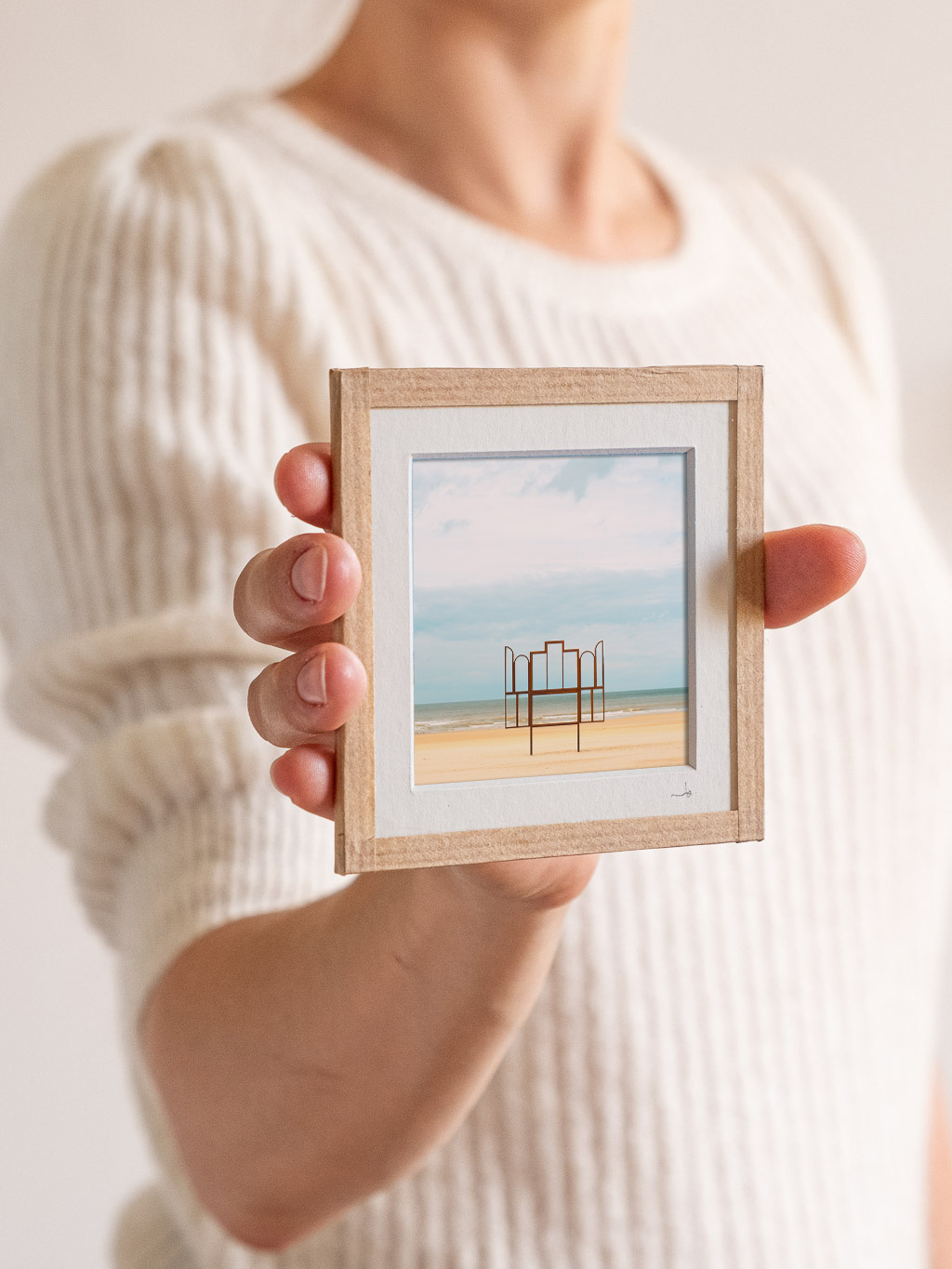 tirage photo petit format encadré à la main représentant un panneau triptyque en métal sur la plage d'Os