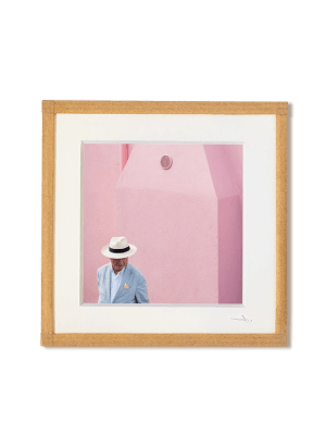 tirage photo petit format encadré à la main représentant un homme portant une chapeau Panama devant un mur rose