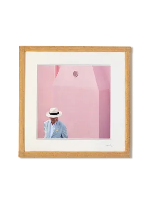 tirage photo petit format encadré à la main représentant un homme portant une chapeau Panama devant un mur rose