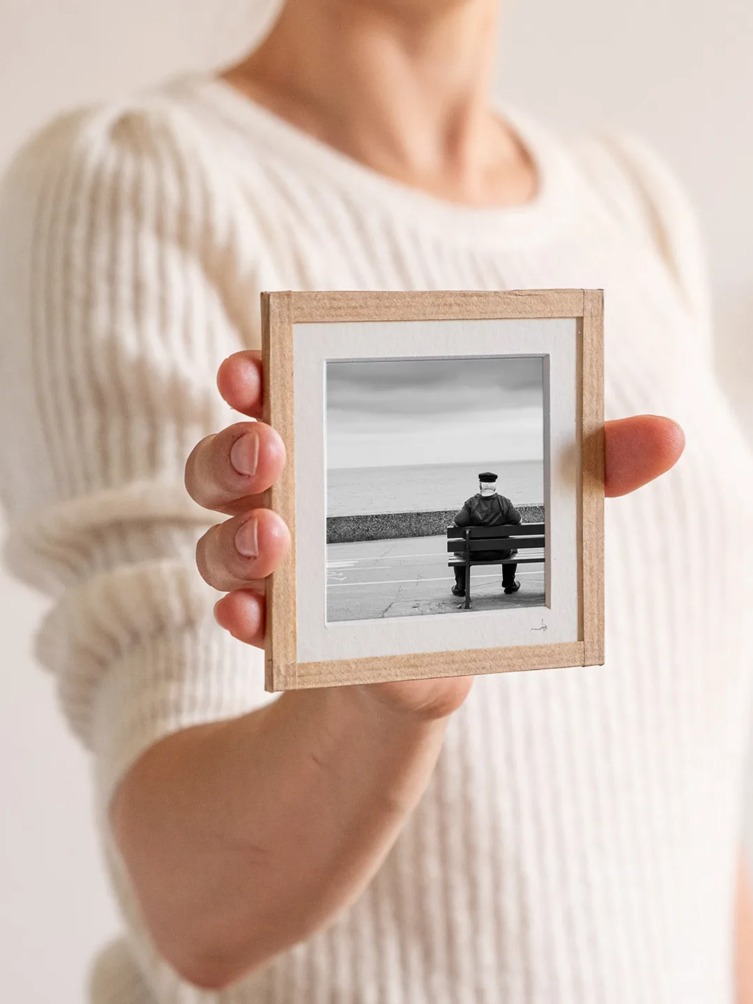 tirage photo petit format encadré à la main représentant un vieil homme au look d'un marin assis de dos sur un banc face à la mer