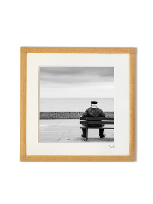 tirage photo petit format encadré à la main représentant un vieil homme au look d'un marin assis de dos sur un banc face à la mer