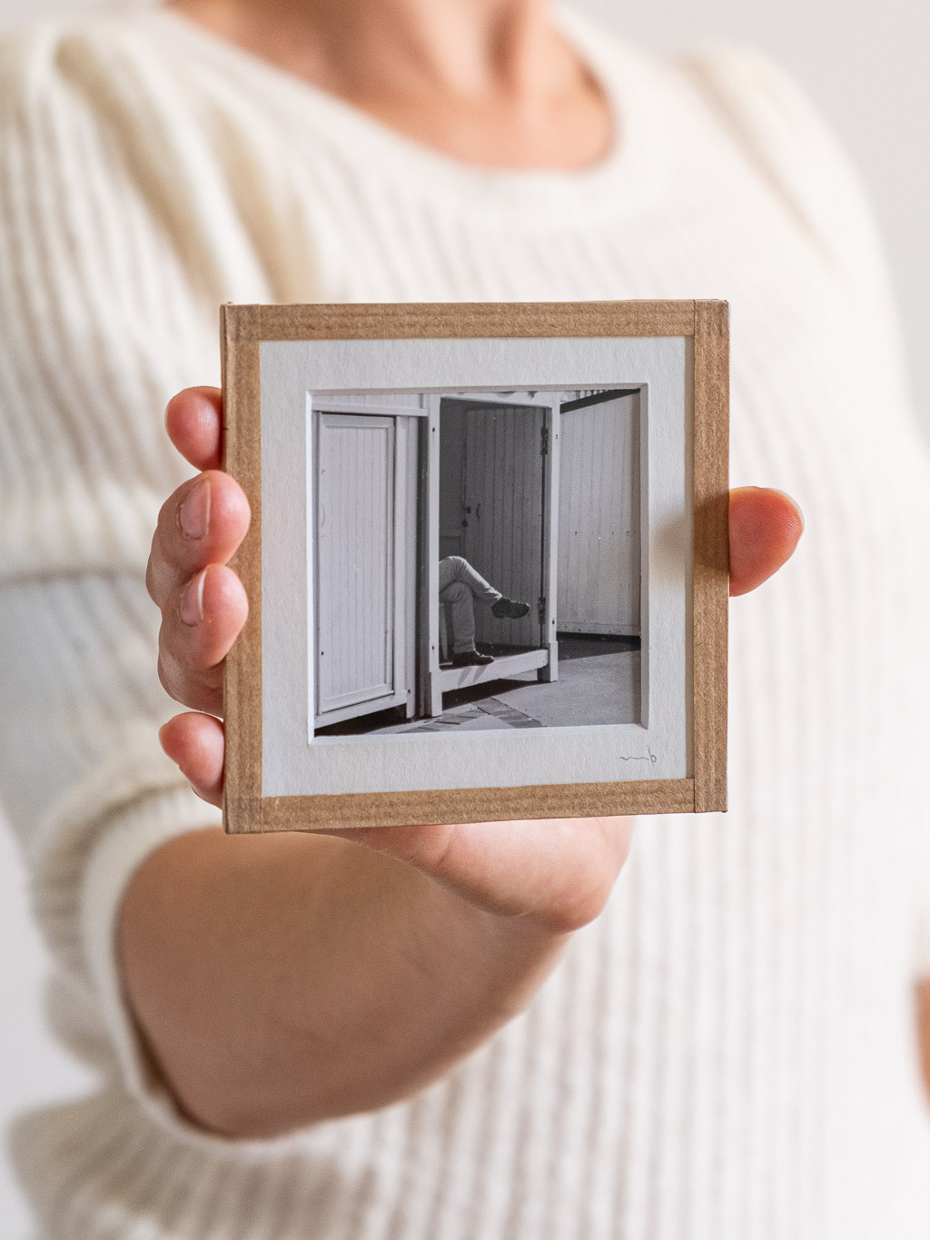 tirage photo petit format encadré à la main représentant une personne cachée dans une cabine de plage