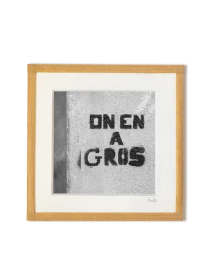 tirage photo petit format encadré à la main représentant un tag au pochoir sur un mur disant "on en a gros"