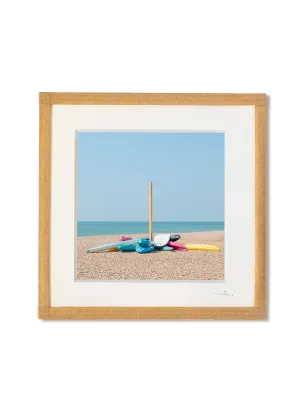 tirage photo petit format encadré à la main représentant des kayaks colorés accrochés à un poteau sur la plage de galet de Brigthon