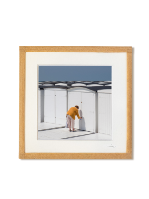 tirage photo petit format encadré à la main représentant une vieille femme de dos ouvrant sa cabines de plage au havre
