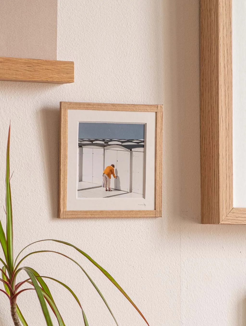 tirage photo petit format encadré à la main représentant une vieille femme de dos ouvrant sa cabines de plage au havre