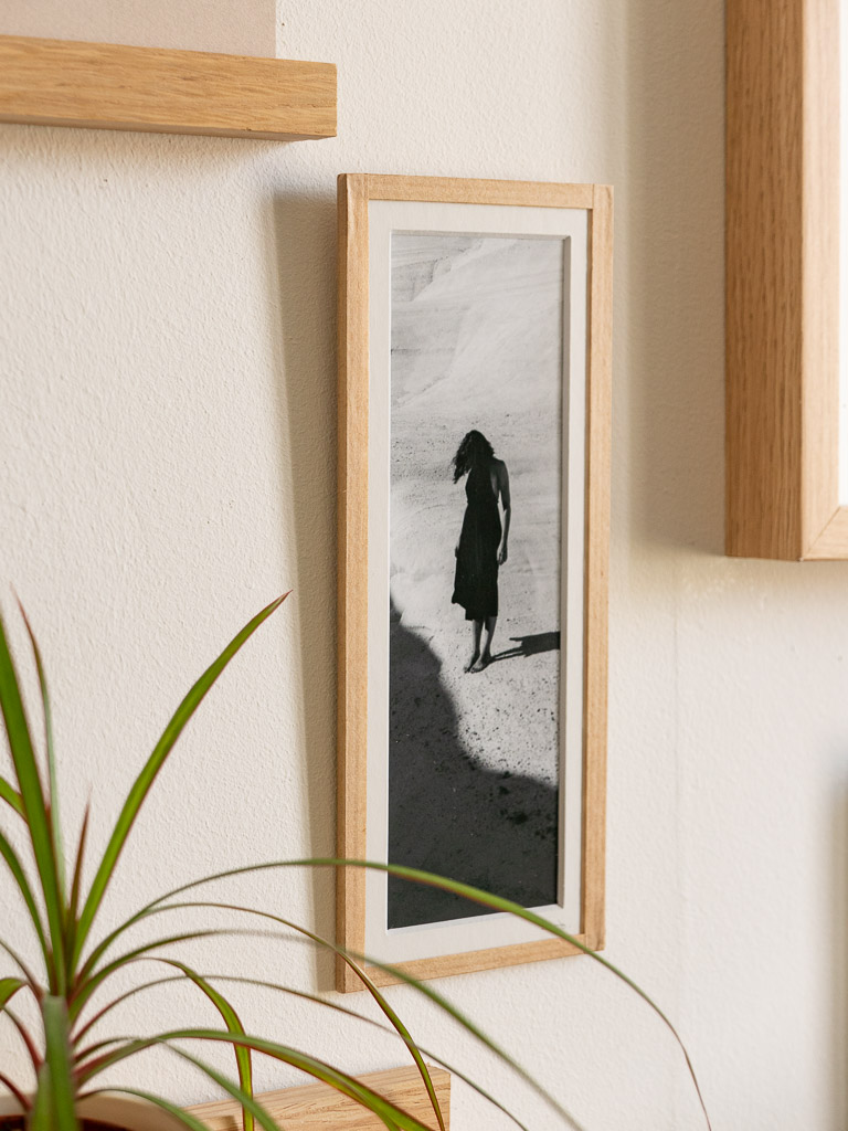 tirage photo petit format encadré à la main représentant une femme en robe noir posant dans les rochers blancs de Milos