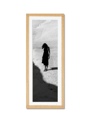 tirage photo petit format encadré à la main représentant une femme en robe noir posant dans les rochers blancs de Milos